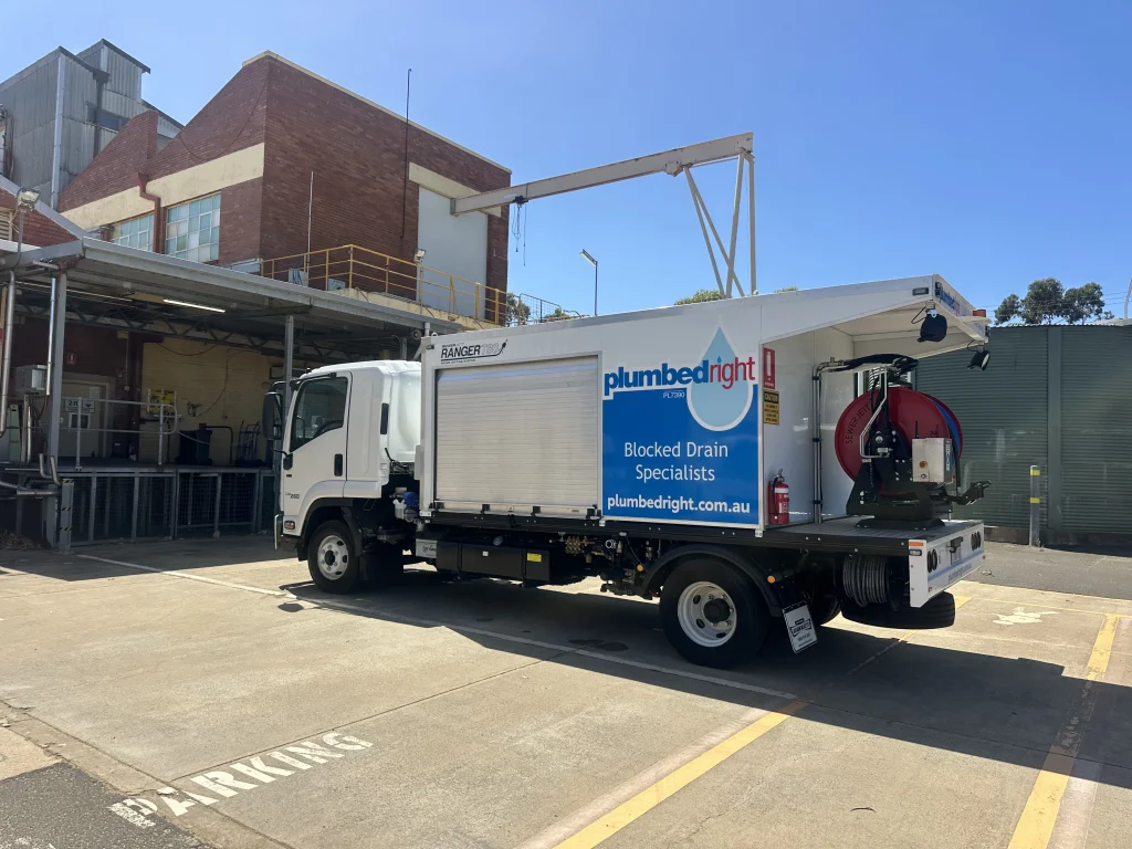 Plumbed Right jetting truck parked at a commercial loading dock