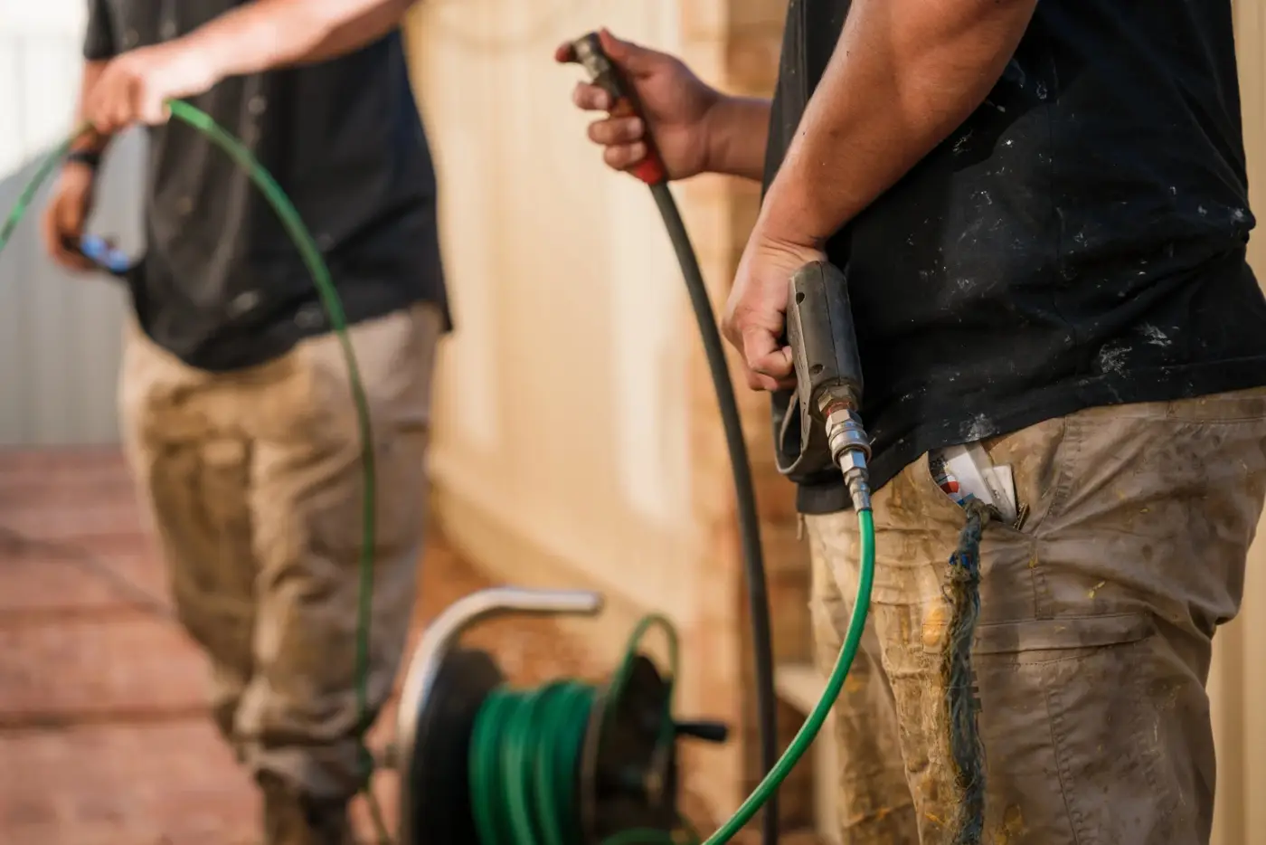 Two techs feeding the jetter hose into a drain