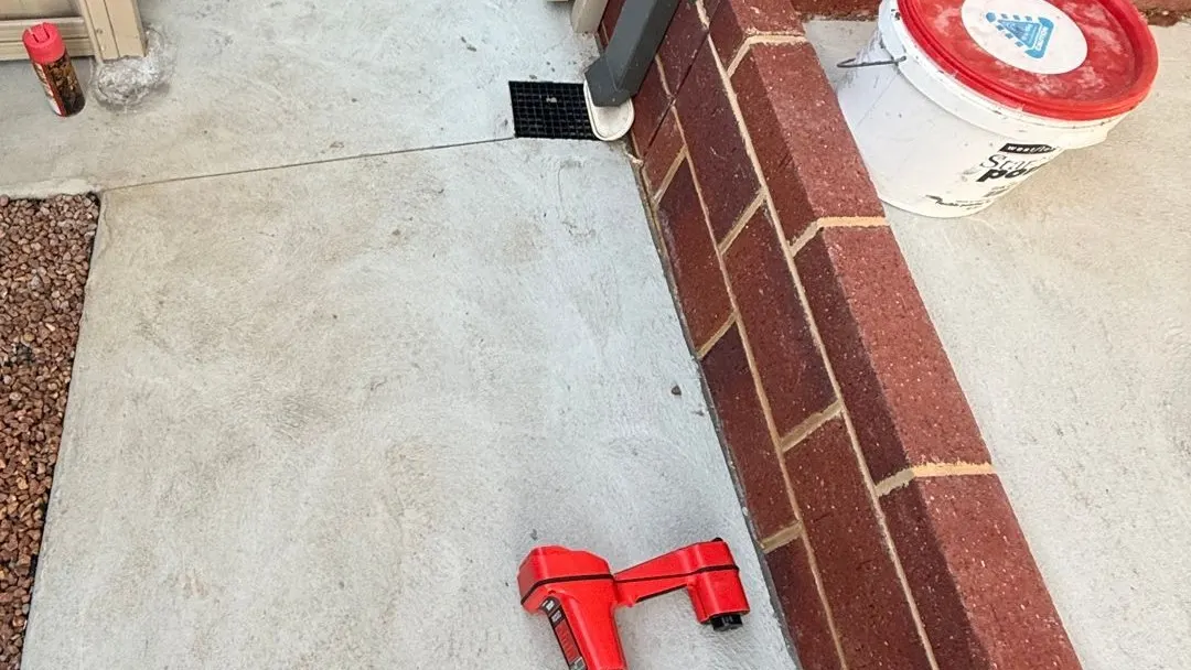 Concrete side path in Heathridge with a stormwater grate at the downpipe and a red drain locator on the slab