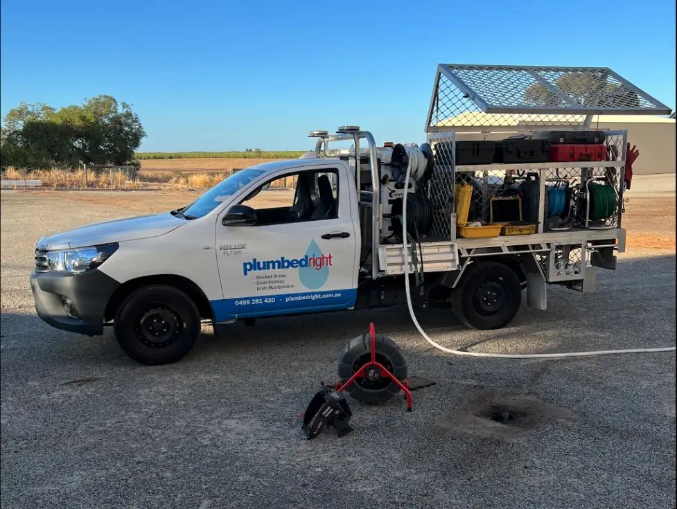 Ute with a CCTV reel on the ground beside an open drain pit
